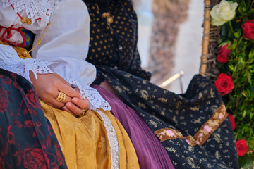 A woman dressed in typical Sardinian costume with different Sardinian ornamental golden jewels.