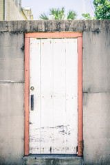 Coral and White Door in a Concrete Wall