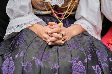 A woman dressed in typical Sardinian costume with different Sardinian ornamental golden jewels.