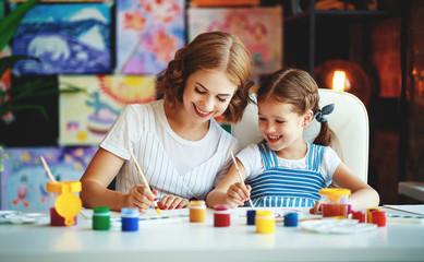 mother and child daughter painting draws in creativity in kindergarten.