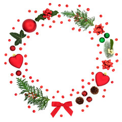 Christmas wreath decoration with loose holly berries, baubles, winter flora and symbols on white background with copy space. Festive concept for the holiday season.