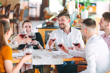 Friends drink wine on the terrace of the restaurant.