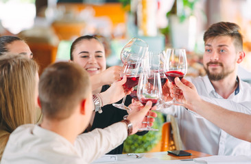 Friends drink wine on the terrace of the restaurant.