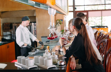 The chef prepares food in front of the visitors in the restaurant