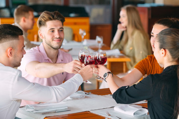 Friends drink wine on the terrace of the restaurant.