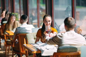 A young couple drinking wine in a restaurant near the window.