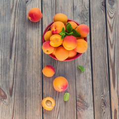 Ripe apricots in a bowl on wooden rustic background square image