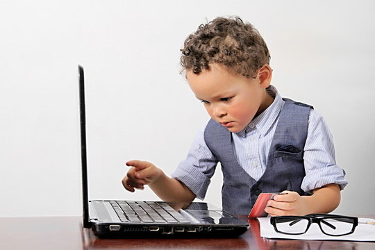 little boy looking at the  laptop computer screen at preschool being educated with credit card white background stock image and stock photo