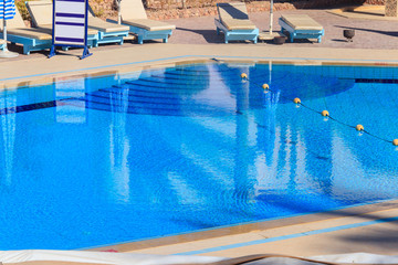 Chaise longues near a swimming pool. Concept of spa, rest, relaxation, holidays, resort