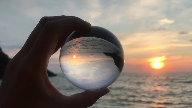 hand holding magic crystall ball over beautiful nature landscape, travel concept