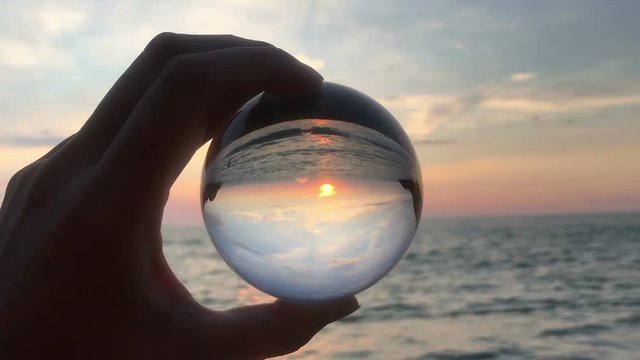 hand holding magic crystall ball over beautiful nature landscape, travel concept
