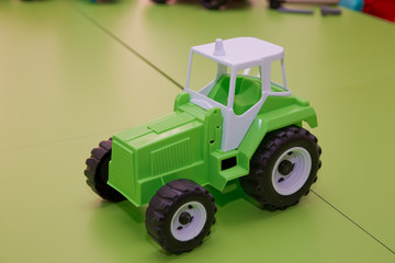 Toy for children. Toy tractor on green background . Green Tractor.