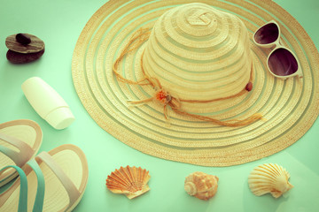 a holiday photo, a summer hat, beach sandals, sunscreen, sun glasses, scallops and souvenir pebbles