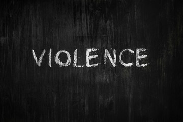 Violence word handwritten on black wood background. Sign, concept of dealing with abusive or toxic  issues - the word 