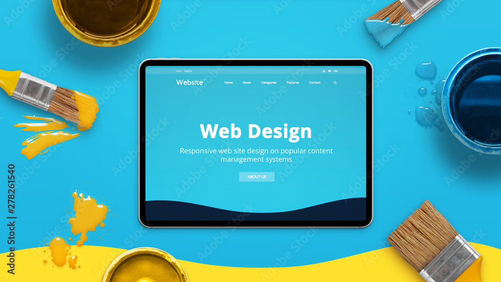 Poster Web design concept with modern flat design theme on a thin tablet surrounded by color brushes and boxes. Top view, flat lay.