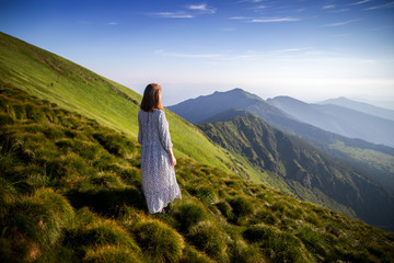 Girl in long white dress in the mountains