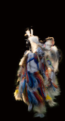 Motion blurred image of a Native Americans powwow dance on black background