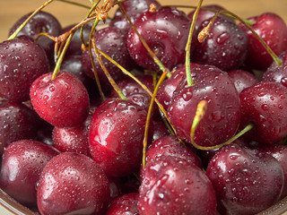 Delicious juicy cherries,lying on a beautiful plate.On wood background