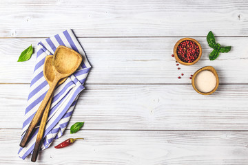 Cooking wooden utensils on white wooden background.
