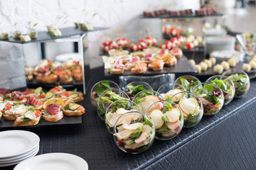 Beautifully decorated catering banquet table with different food snacks and appetizers.