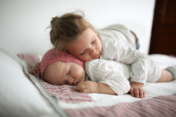 Fototapeta na wymiar Toddler Girl Hugs a Sleeper Cute little baby