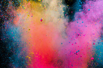 Colored powder explosion on black background. Freeze motion.