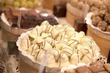 Asorted chocolate truffles and pralines. Chocolate and coconut candies on the counter in the confectionery store