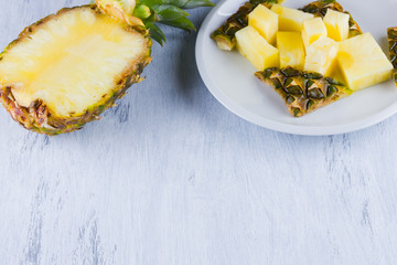 Pineapple slices on a gray background. Sliced pineapple on a white plate. Tropical fruit for vegan. Top view. Copy space