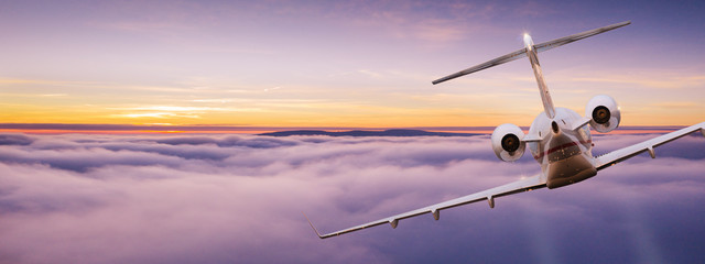 Fototapeta premium Small private jetplane flying above beautiful clouds. Travel and transportation concept.