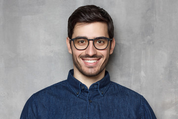 Obraz premium Headshot of guy wearing spectacles looking at camera with smile, isolated on background