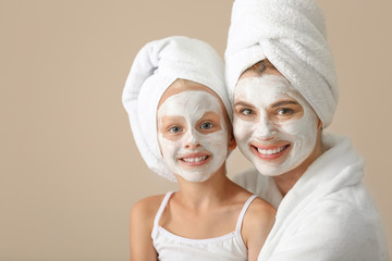 Portrait of mother and little daughter after shower on color background