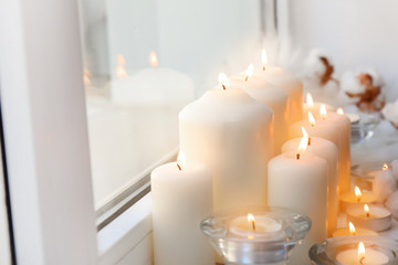 Fototapeta na wymiar Beautiful burning candles on window sill