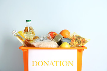 Box with donation food on light background