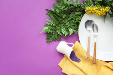 Beautiful table setting with floral decor on color background