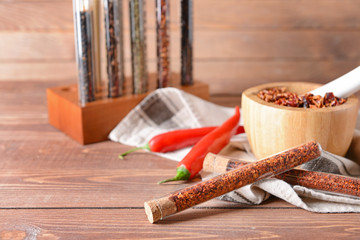 Dry pepper in tubes on wooden table