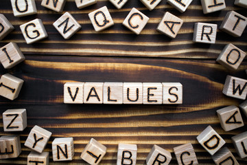 Obraz premium word values composed of wooden cubes with letters, what is right and wrong concept, scattered around the cubes random letters, top view on wooden background