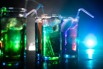 collection of colorful shots with lemon on bar; set of alcohol mini cocktail shooters with lime;