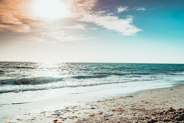 The Sun begins to set over crystal blue ocean waters of the gulf of mexico