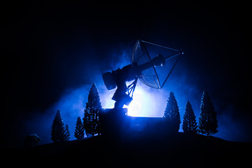 Silhouettes of satellite dishes or radio antennas against night sky. Space observatory.