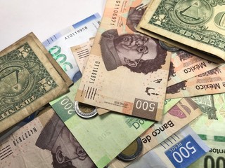 Mexican peso bills spread over white background