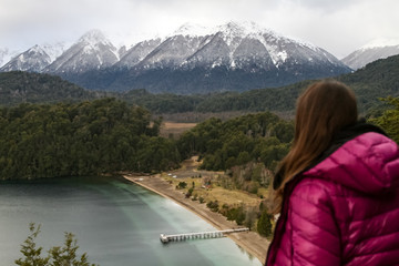 mujer de espaldas mirando el lago y las montañas