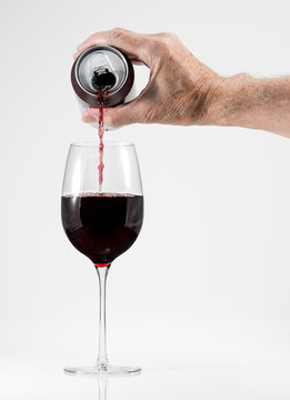 Senior man hand pouring a glass of red wine from a single serving can