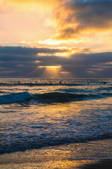 Fototapeta na wymiar surfers and waves at sunset