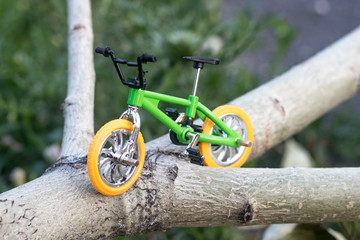 the bike is on a log, it is a small bike, a small copy of a mountain bike
