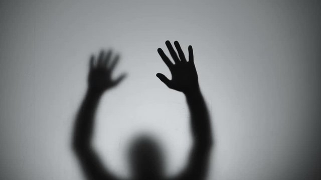 Silhouette behind glass wall trying to getting out, escape, flashing lights
