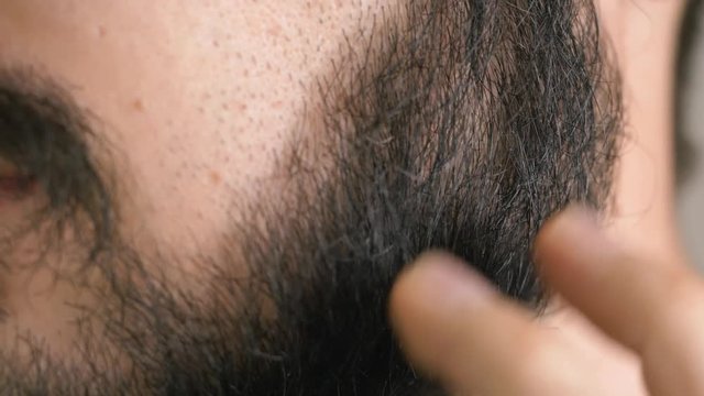 closeup on a man with an itchy beard