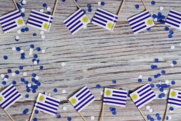 happy Uruguay independence day. August 25. the concept of freedom, independence and patriotism. mini flags with confetti on wooden background. horizontal