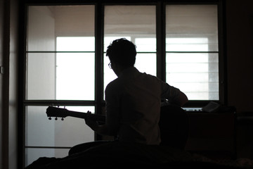 silhouette of musician in front of window