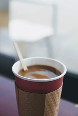 Close up of fresh hot coffee in a paper cup. 