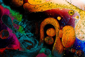 Macro shot of water oil emulsion over colored background